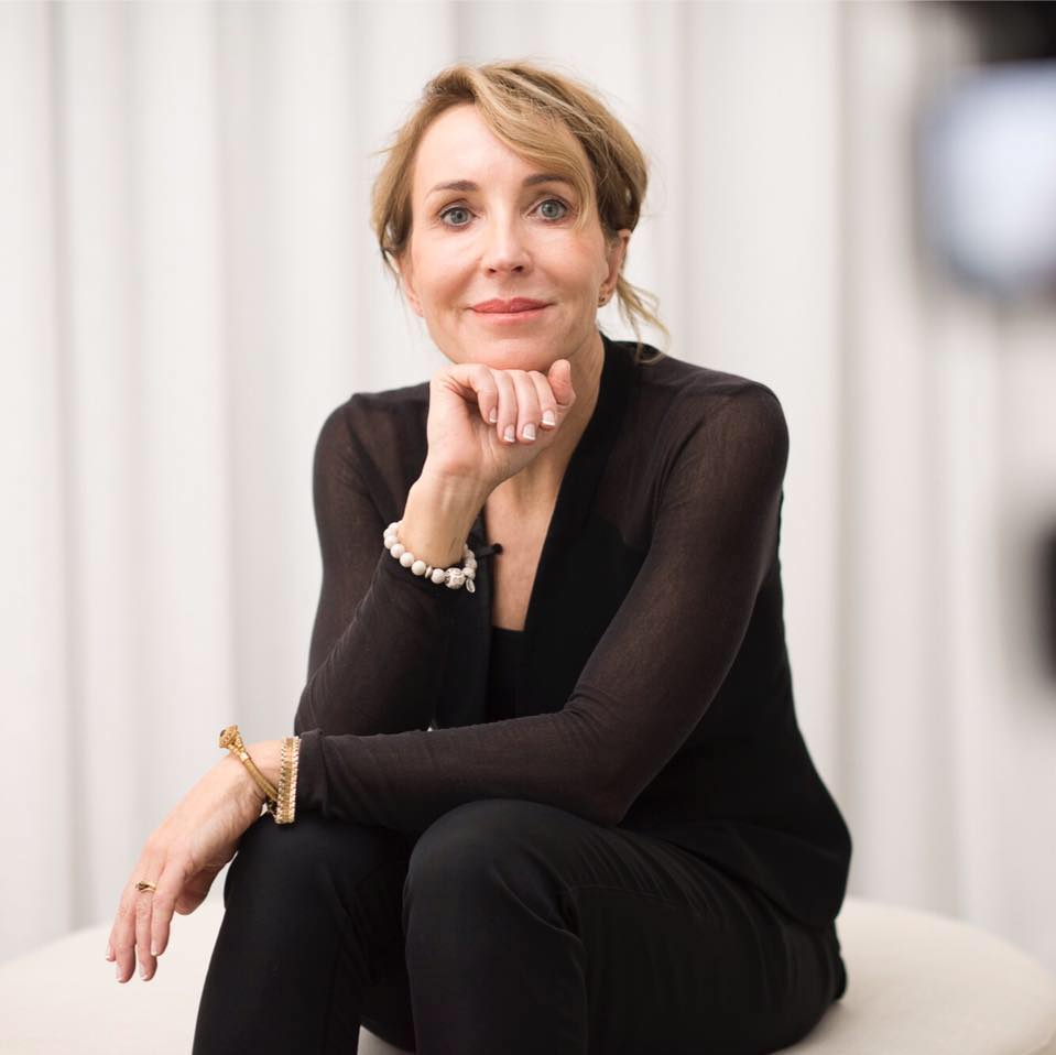 Dr Alison Jamieson seated in a black top on set, hand under her chin — Aliangé founder update