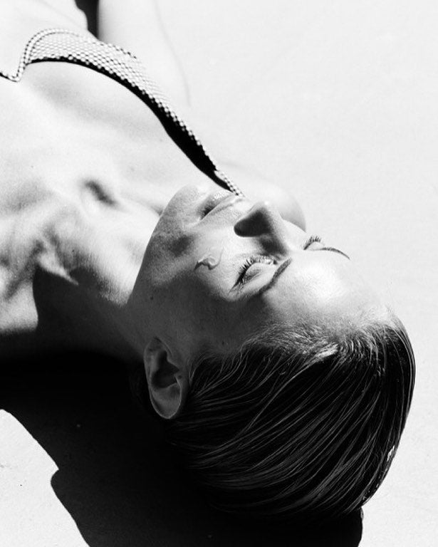 Black-and-white portrait of a woman lying back with her eyes closed — biopolymers in skincare