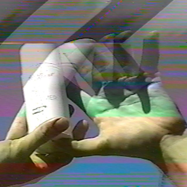 Glitched video still of hands holding a white bottle in saturated colour — living most of my life article